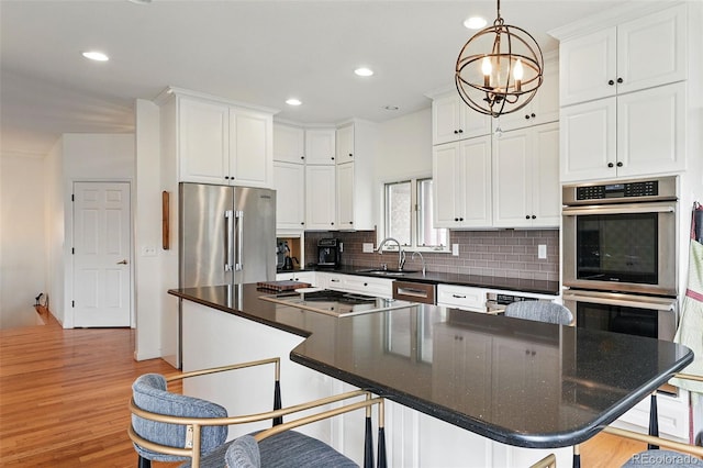 4212 E Orchard Pl, Centennial, CO 80121 - kitchen featuring appliances with stainless steel finishes, a sink, tasteful backsplash, white cabinets, and dark countertops