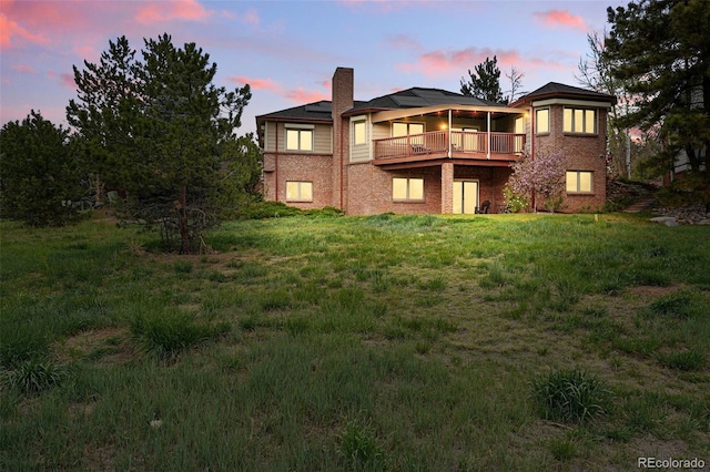 4212 E Orchard Pl, Centennial, CO 80121 - rear view of property with brick siding, a chimney, a wooden deck, and solar panels