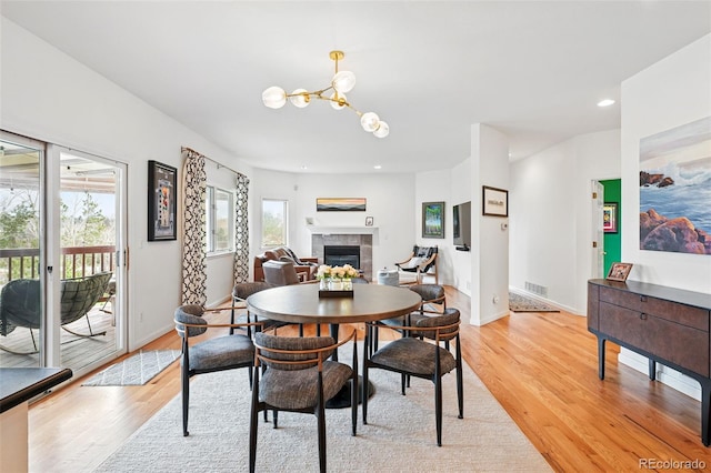 4212 E Orchard Pl, Centennial, CO 80121 - dining area with light wood-style floors, a tile fireplace, baseboards, a chandelier, and recessed lighting