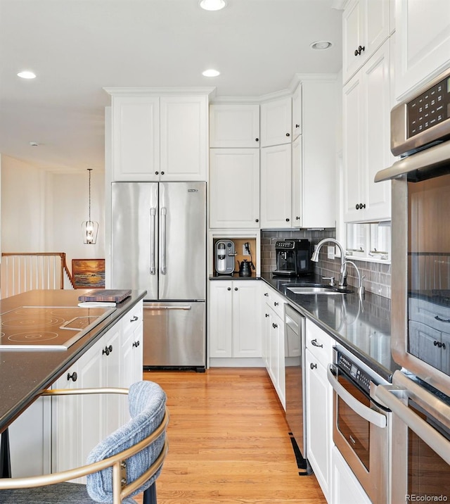 4212 E Orchard Pl, Centennial, CO 80121 - kitchen with stainless steel appliances, white cabinetry, dark countertops, a sink, and recessed lighting
