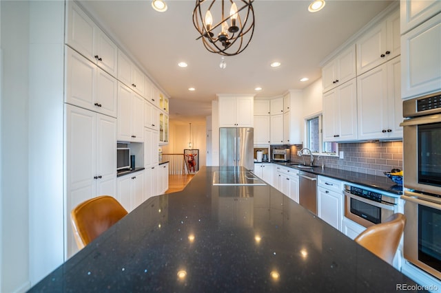 4212 E Orchard Pl, Centennial, CO 80121 - kitchen featuring stainless steel appliances, a sink, a chandelier, backsplash, and recessed lighting