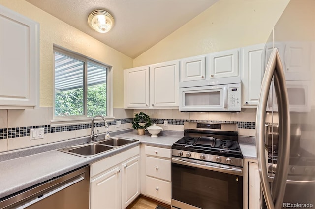 9627 Franklin St, Thornton, CO 80229 - kitchen with appliances with stainless steel finishes, lofted ceiling, backsplash, white cabinets, and light countertops