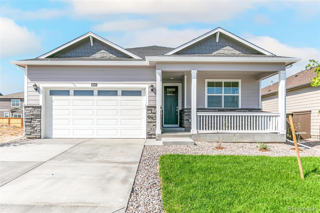 craftsman house featuring a garage, covered porch, and a front yard