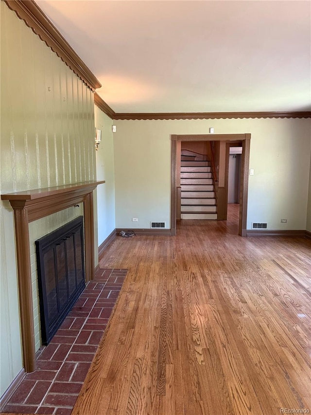 6375 E 6th Avenue Parkway, Denver, CO 80220 - unfurnished living room with stairway, a tiled fireplace, ornamental molding, and wood finished floors