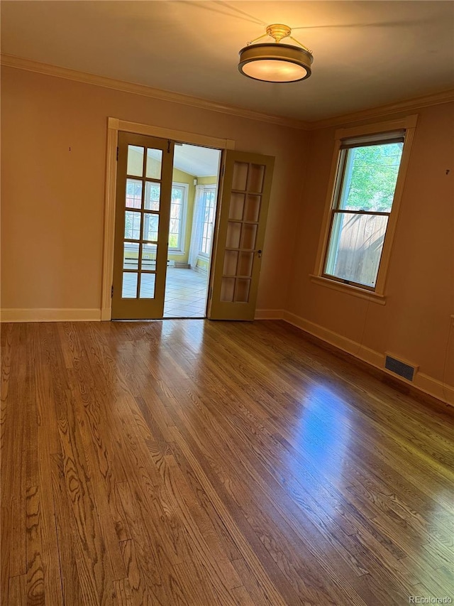 6375 E 6th Avenue Parkway, Denver, CO 80220 - empty room featuring wood finished floors, healthy amount of natural light, ornamental molding, and french doors