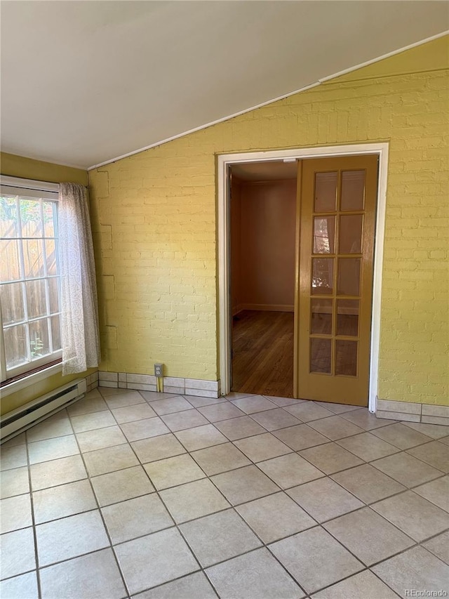 6375 E 6th Avenue Parkway, Denver, CO 80220 - empty room with lofted ceiling, brick wall, a baseboard radiator, and light tile patterned floors