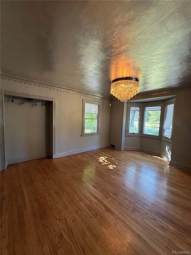 6375 E 6th Avenue Parkway, Denver, CO 80220 - unfurnished living room featuring a chandelier and wood finished floors