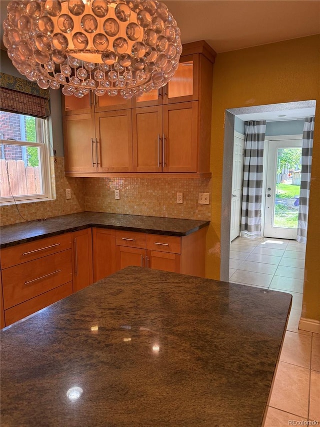 6375 E 6th Avenue Parkway, Denver, CO 80220 - kitchen featuring light tile patterned flooring, backsplash, and brown cabinets