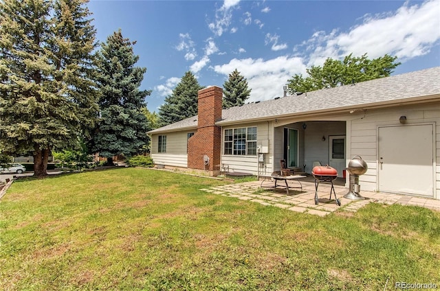 rear view of property featuring a lawn and a patio