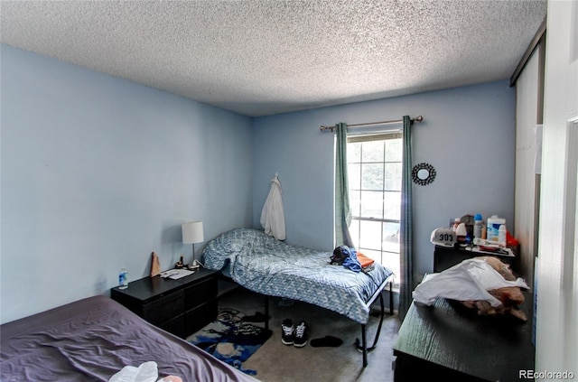 bedroom featuring a textured ceiling and carpet flooring