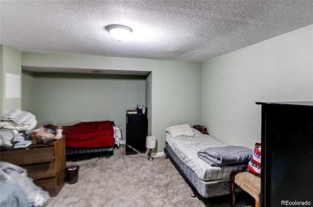 bedroom with light colored carpet and a textured ceiling