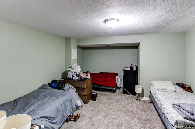 bedroom featuring a textured ceiling and light colored carpet