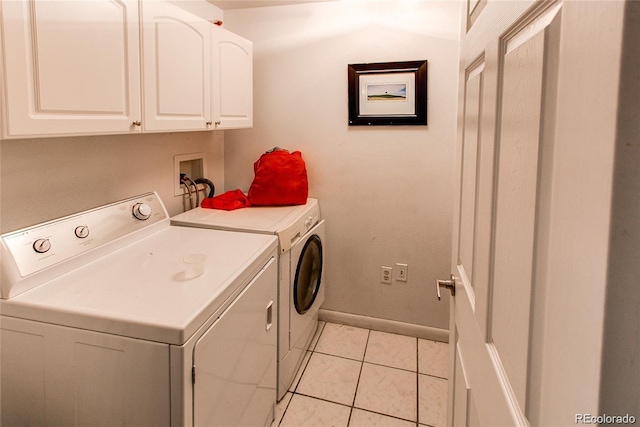 laundry room featuring light tile flooring, washer hookup, separate washer and dryer, and cabinets