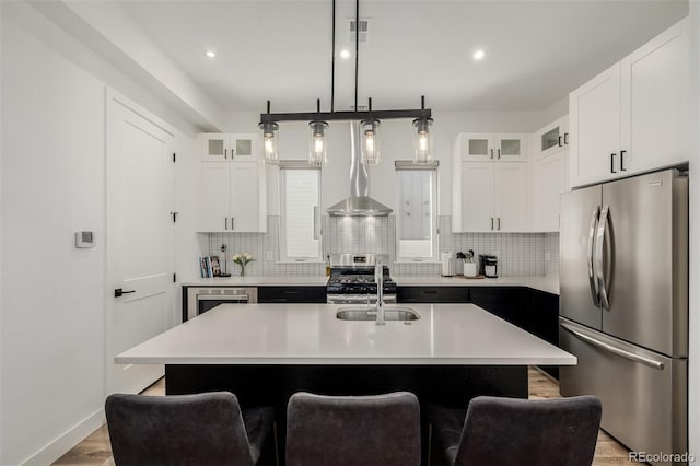 kitchen featuring stainless steel appliances, tasteful backsplash, and a center island with sink