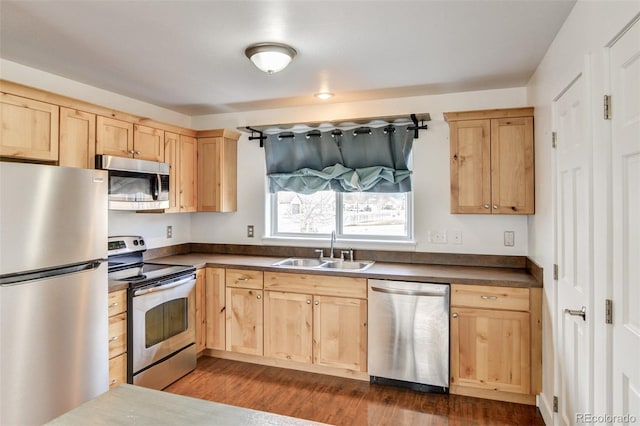 kitchen featuring stainless steel appliances, sink, dark wood-type flooring, and light brown cabinetry