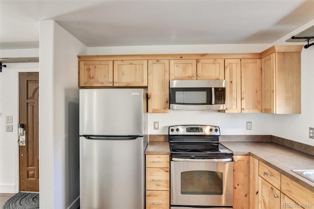 kitchen featuring stainless steel appliances and light brown cabinets