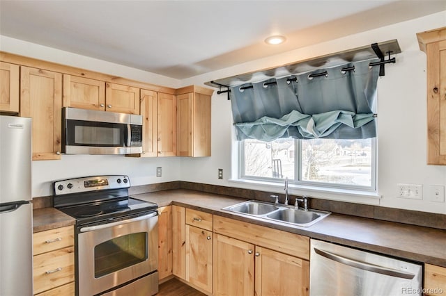 kitchen featuring appliances with stainless steel finishes, sink, and light brown cabinets