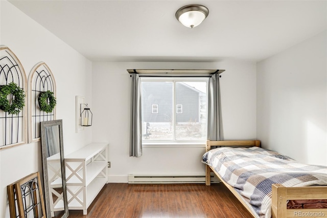 bedroom featuring a baseboard heating unit and dark wood-type flooring