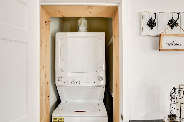 washroom featuring stacked washer and clothes dryer