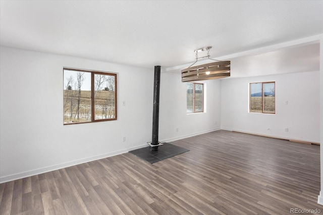 unfurnished room featuring plenty of natural light and dark wood-type flooring