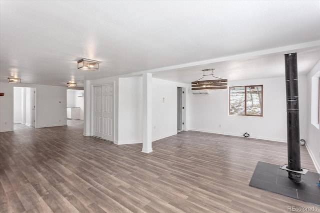 unfurnished living room featuring an AC wall unit and hardwood / wood-style floors