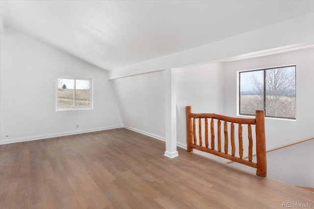 additional living space with vaulted ceiling and hardwood / wood-style flooring