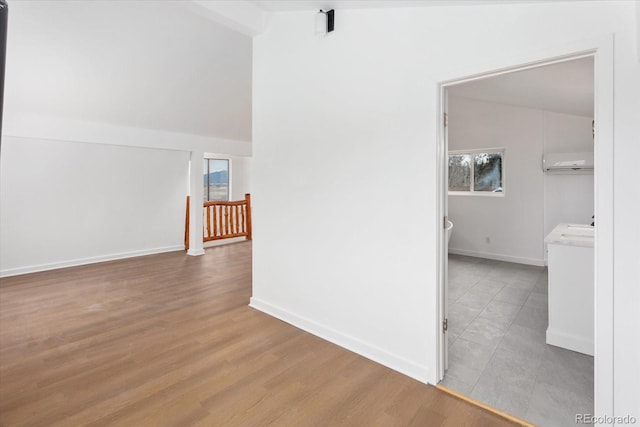 corridor with vaulted ceiling and a wall mounted AC