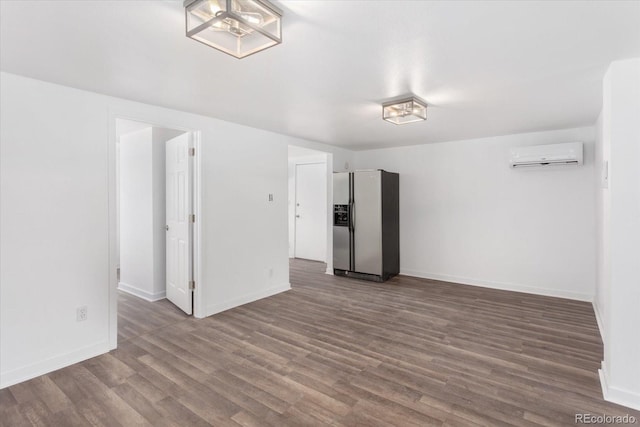 unfurnished room featuring dark hardwood / wood-style flooring and an AC wall unit