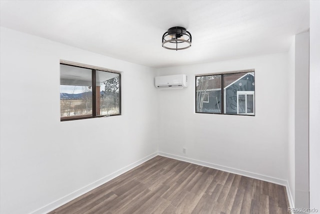 empty room featuring a wall mounted air conditioner and hardwood / wood-style floors