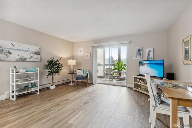 home office featuring light hardwood / wood-style flooring, a textured ceiling, and a baseboard heating unit