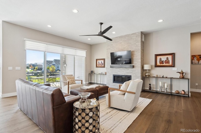 living area with light wood-style flooring, a fireplace, and baseboards