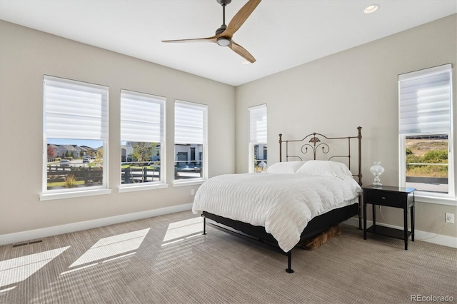 bedroom featuring light colored carpet, multiple windows, and visible vents