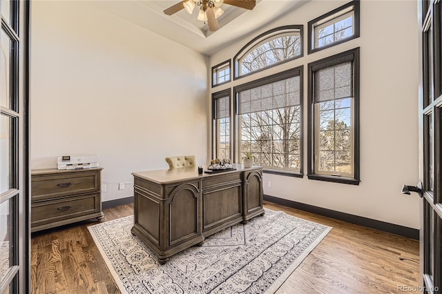 office with baseboards, dark wood finished floors, and a ceiling fan