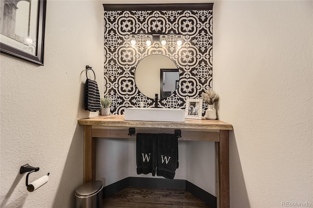 room details featuring baseboards, wood finished floors, and vanity