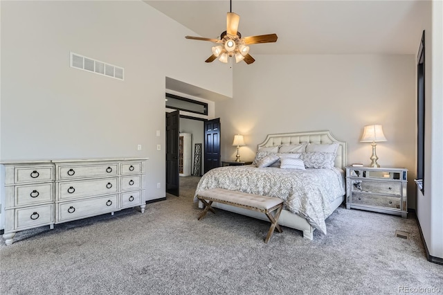 carpeted bedroom with baseboards, visible vents, high vaulted ceiling, and ceiling fan