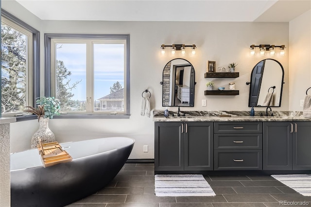 bathroom featuring double vanity, a soaking tub, and a sink