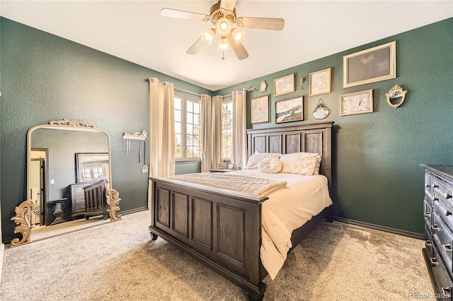 bedroom featuring a ceiling fan, carpet flooring, a textured wall, and baseboards