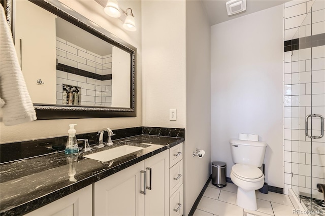 bathroom with baseboards, toilet, a stall shower, tile patterned floors, and vanity