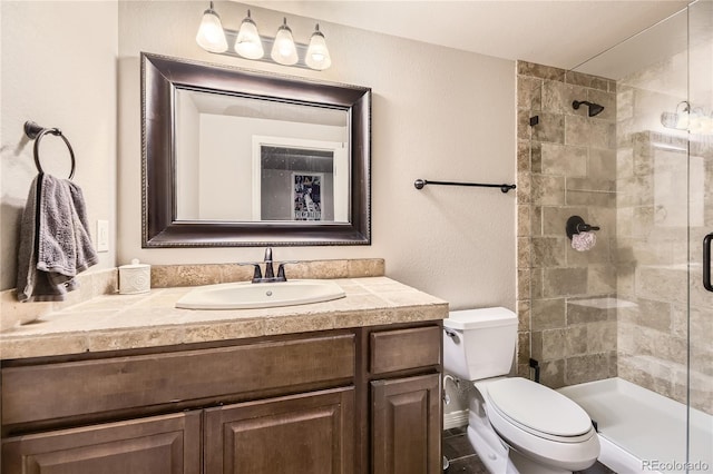 bathroom with vanity, a shower stall, and toilet