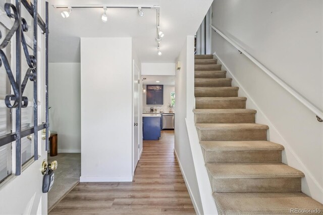 8445 Lamar Dr, Arvada, CO 80003 - staircase featuring track lighting and wood finished floors