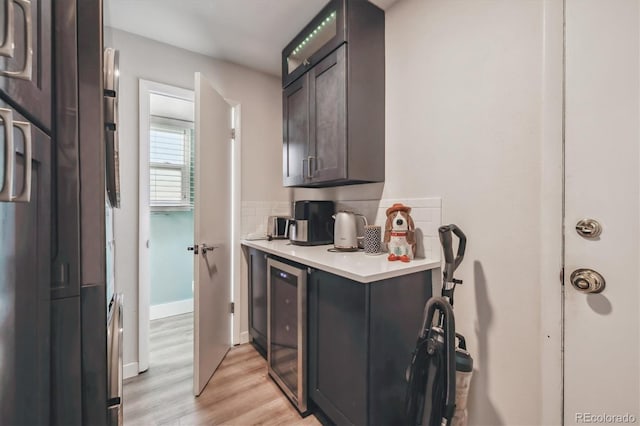 8445 Lamar Dr, Arvada, CO 80003 - kitchen featuring fridge, wine cooler, light countertops, light wood finished floors, and backsplash
