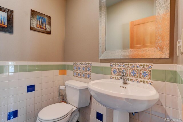 116 Ramona Rd, Golden, CO 80403 - half bathroom featuring tile walls, toilet, and a wainscoted wall