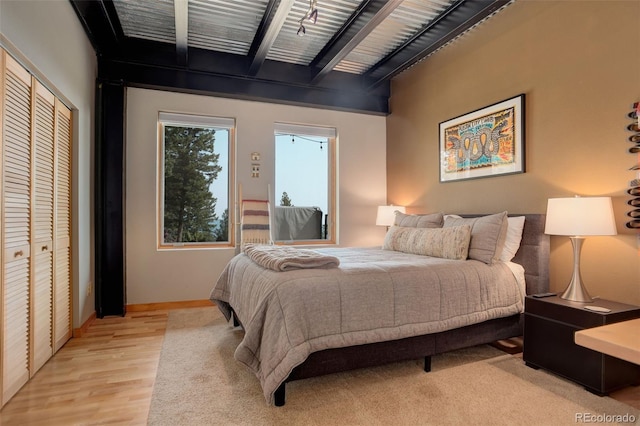116 Ramona Rd, Golden, CO 80403 - bedroom with beam ceiling, light wood-style flooring, a closet, and baseboards