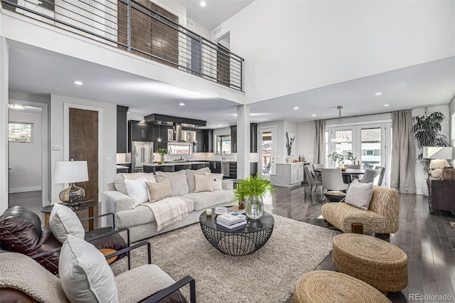 living room featuring dark wood-style floors, recessed lighting, and a high ceiling