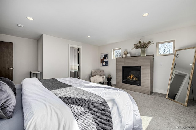 bedroom with recessed lighting, baseboards, light colored carpet, and a fireplace