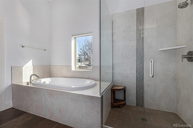 full bath featuring a garden tub and a tile shower