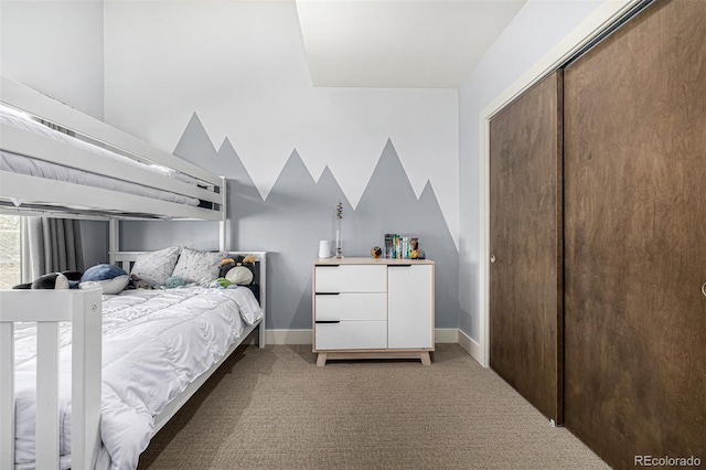 bedroom with a closet, carpet floors, baseboards, and vaulted ceiling