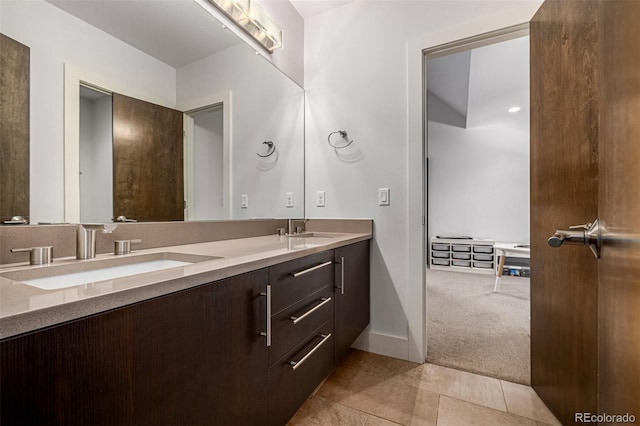 full bathroom featuring double vanity, tile patterned flooring, baseboards, and a sink