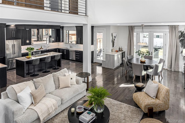 living area featuring dark wood-style floors and a towering ceiling