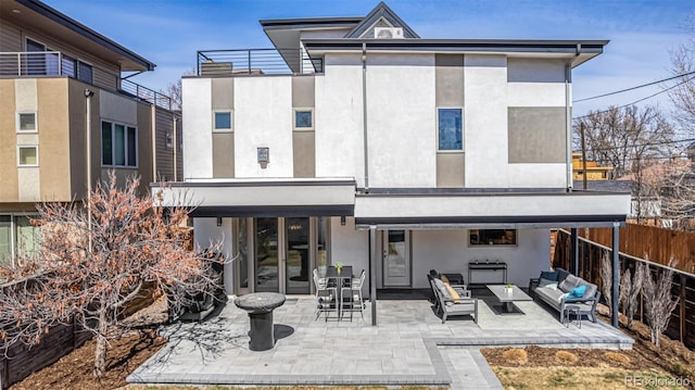 back of property featuring a patio, fence, an outdoor living space, stucco siding, and french doors